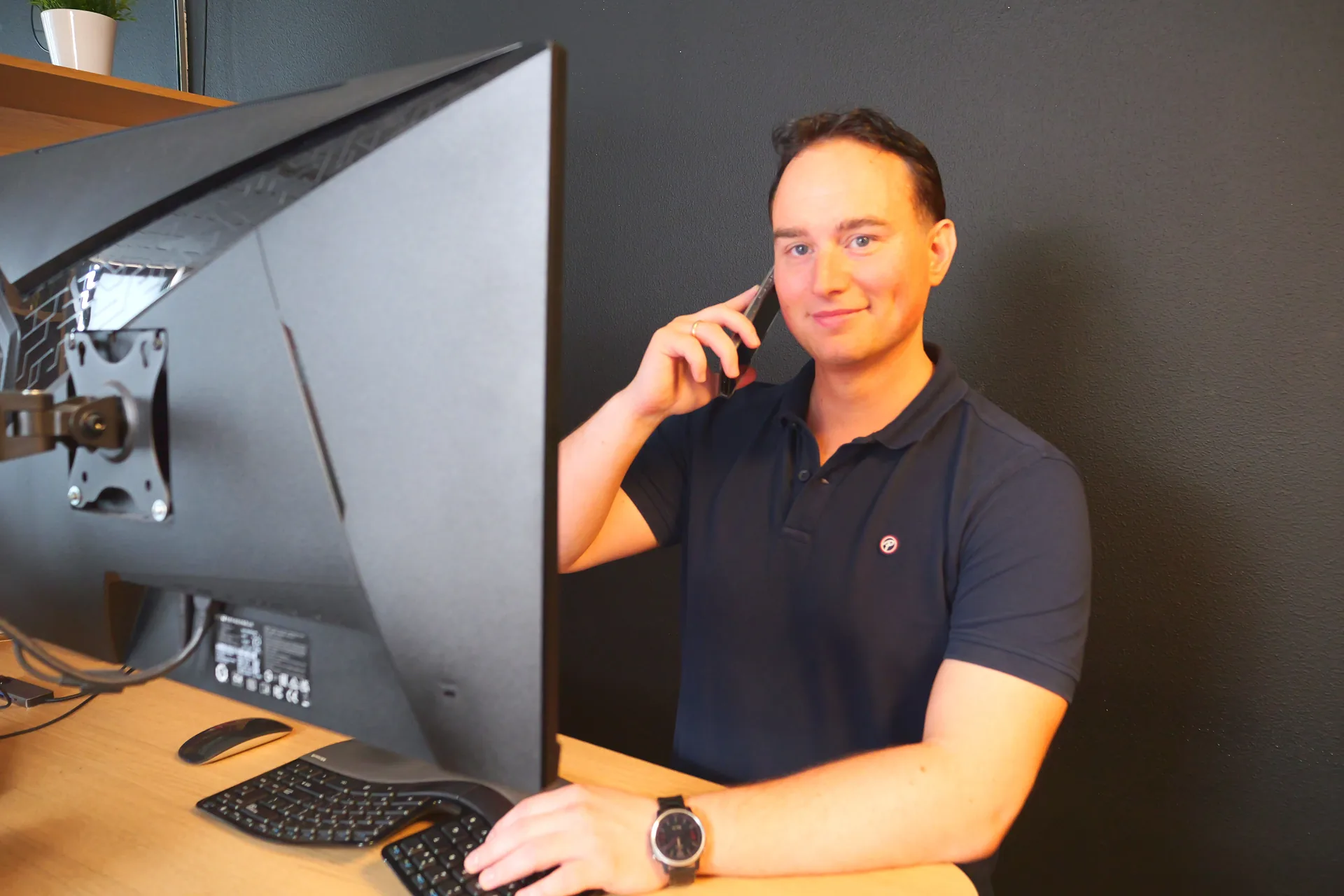 Pascal aan de telefoon achter zijn beeldscherm
